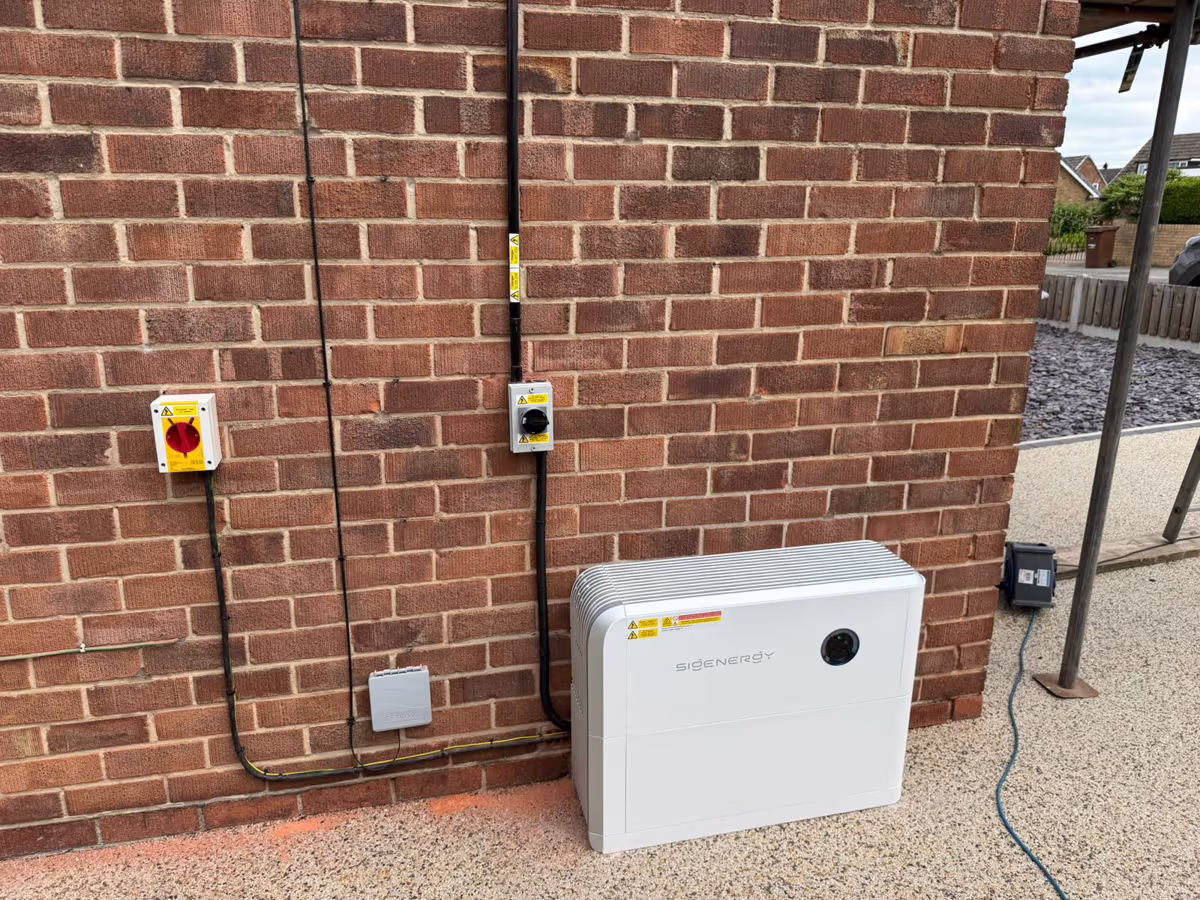 Neat external isolators and battery unit installed on a brick wall